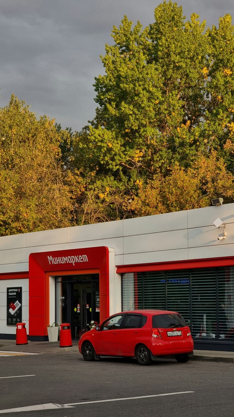 Red store front with a red car parked outside